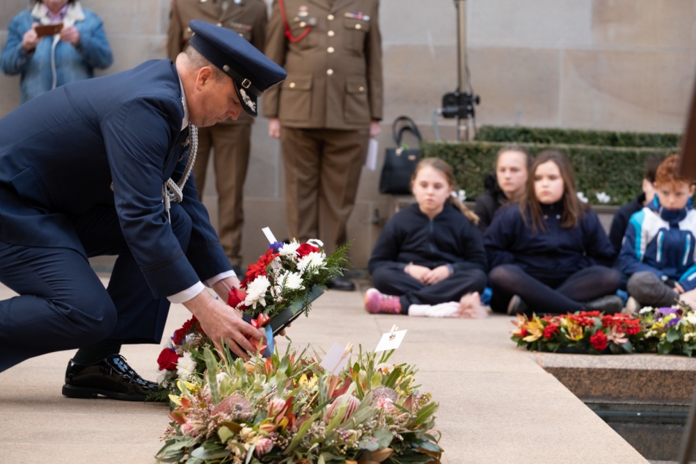Service member lays wreath during ceremony